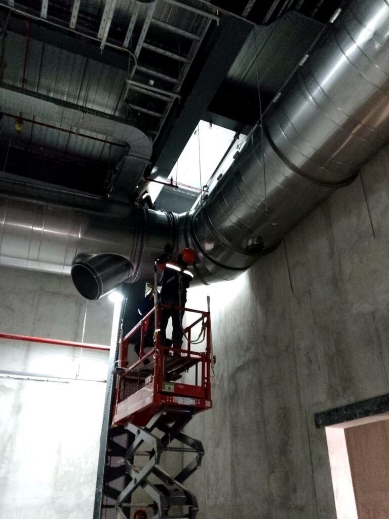 Installer connecting flue sections at height, Cikarang