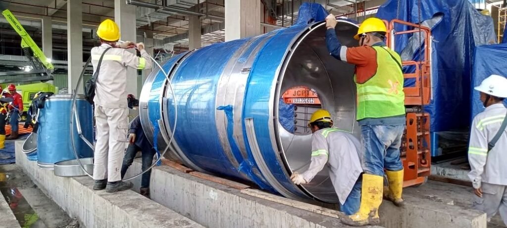 Crew assembling a large double-wall flue section, Surabaya